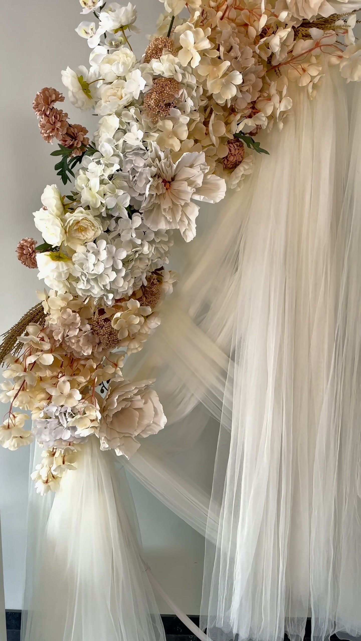 Bloemen die over de witte voile-draperie vallen
